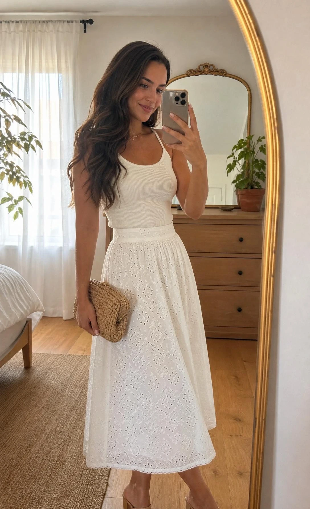 Young woman in white eyelet cotton midi skirt and fitted cream ribbed tank top, a chic summer graduation guest outfit captured in a sunlit bedroom mirror selfie
