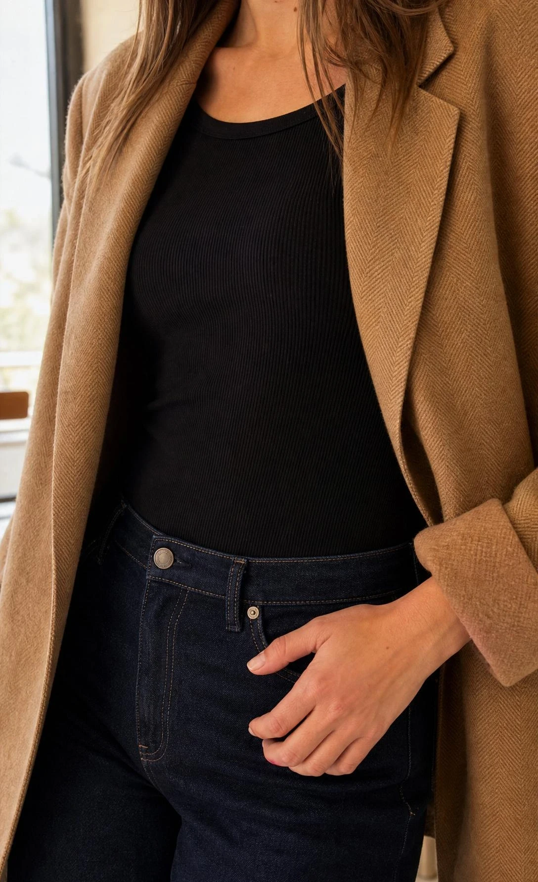 Caramel herringbone blazer worn open over a black ribbed bodysuit tucked into high-waist indigo jeans — a polished brunch outfit with effortless structure