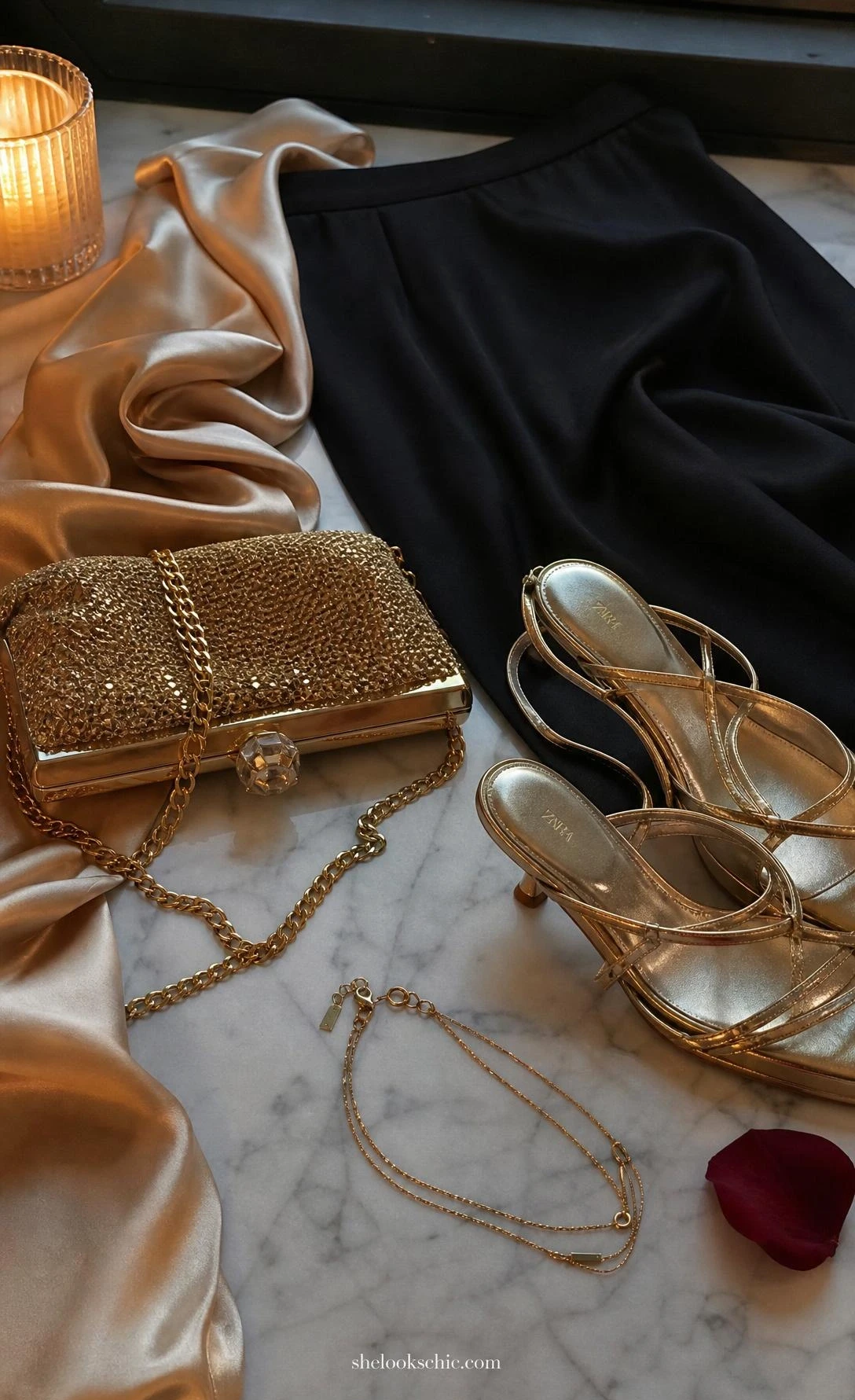 Champagne gold silk camisole draped beside a delicate gold chain necklace, styled details for an elegant black maxi skirt evening outfit