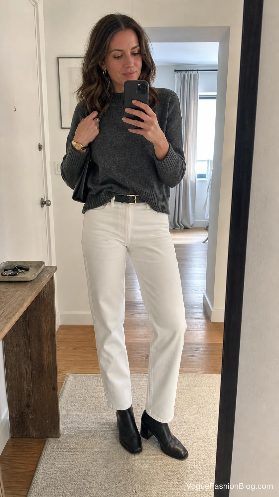 Woman in a charcoal ribbed sweater, straight-leg denim, and black ankle boots styling white jeans after labor day outfits