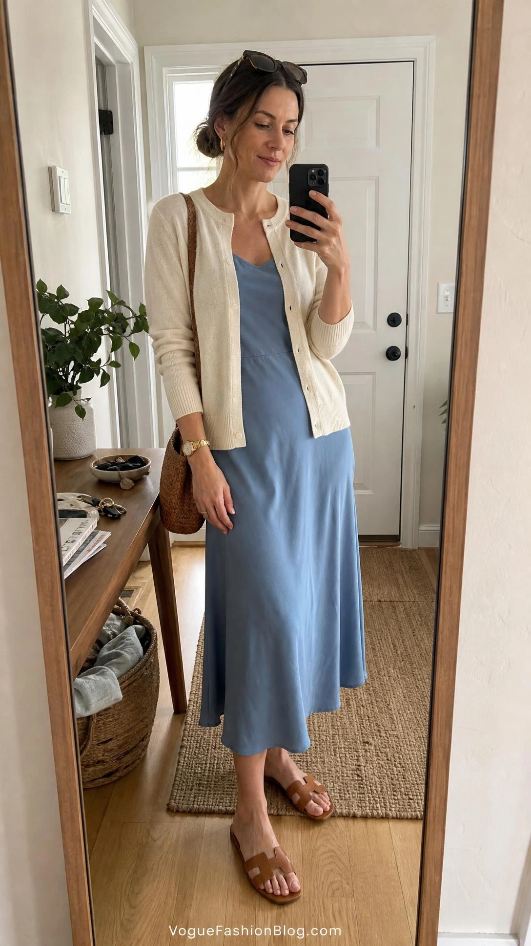 Woman in a lightweight cardigan and midi dress takes an entryway mirror selfie for late summer outfit ideas women.
