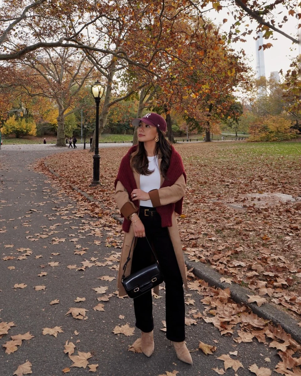 Camel trench coat layered over a burgundy cardigan for a warm, classic Central Park fall walk.