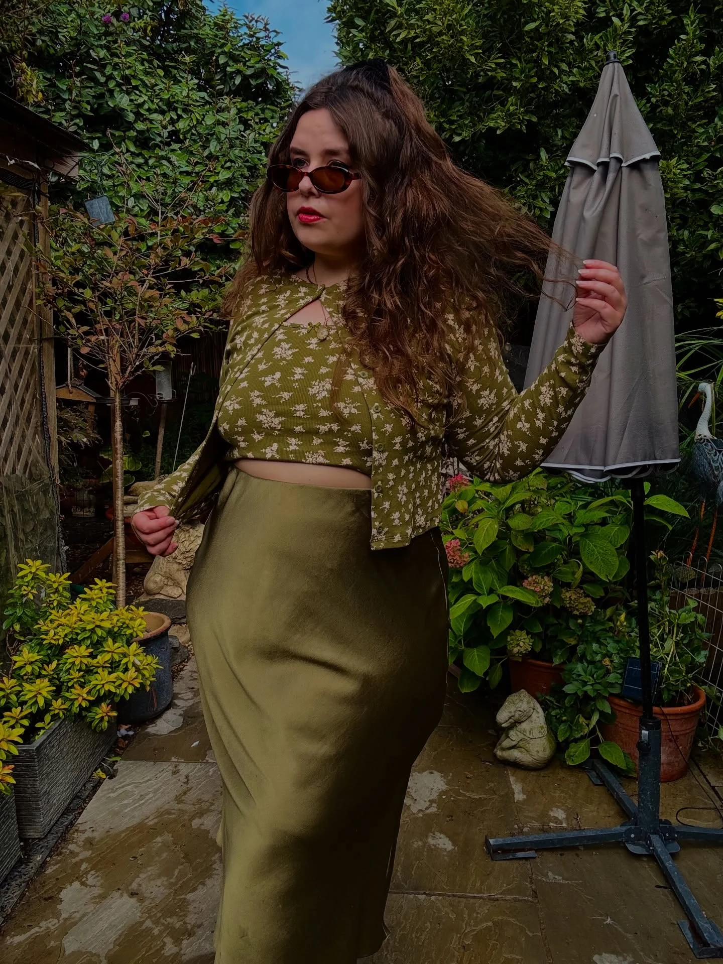 Amy Worcester in olive floral cropped top, open cardigan and high waisted satin midi skirt, size 18.