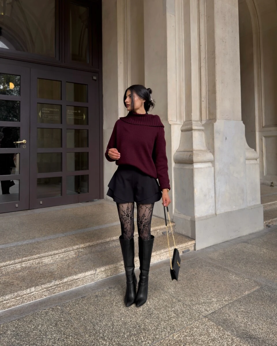 Burgundy ruffle collar sweater paired with black shorts and knee-high boots for a fall night out.