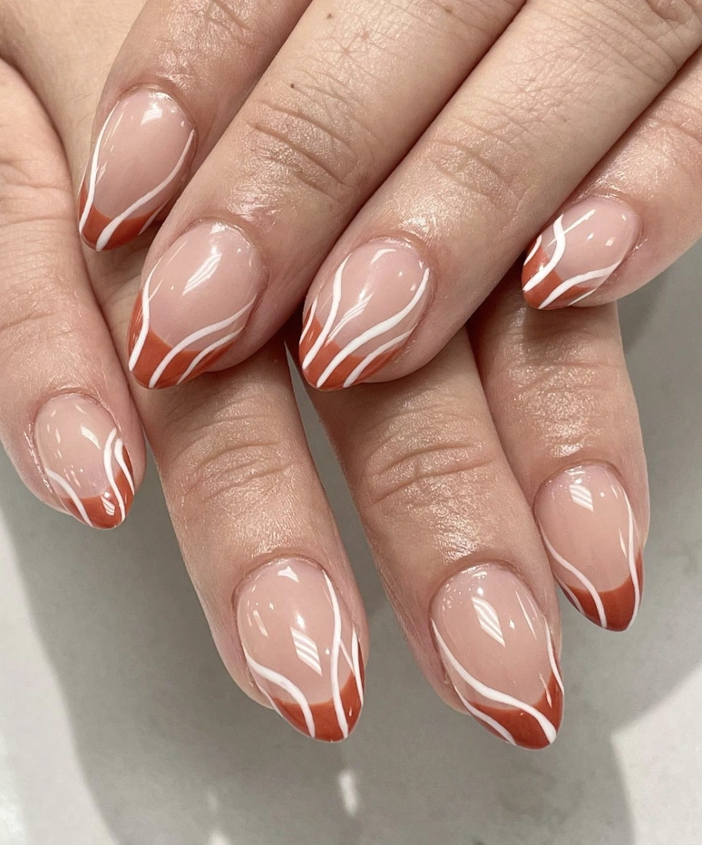 Almond-Shaped Fall French Tips with Warm Rust Hues and Elegant White Swirls
