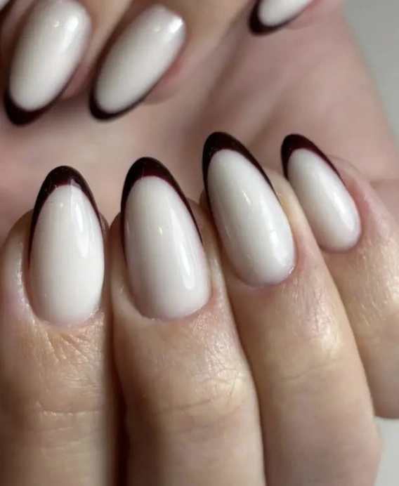 Almond-shaped glossy nude base with burgundy French tips