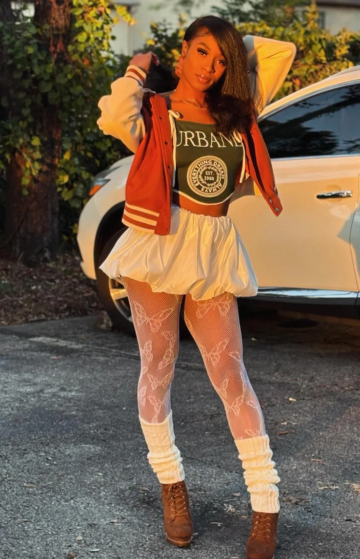 Red Varsity Jacket + Black Graphic Crop Top + White Bubble Mini Skirt + White Lace Tights + Brown Lace-Up Ankle Boots