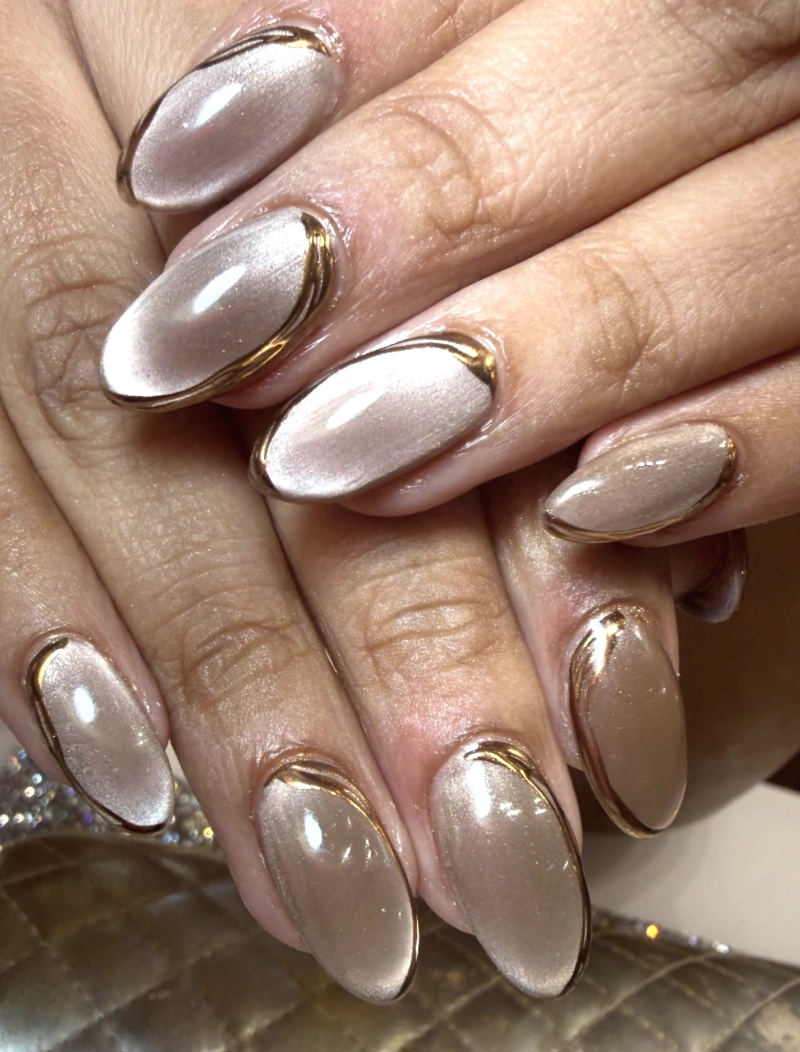 Shimmering Taupe Almond Nails with Gold Chrome Outline