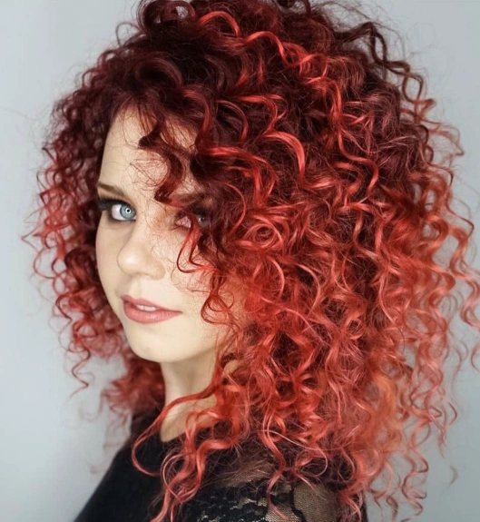 Shoulder-Length Curly Hairstyle with Strawberry Red Hair Highlights