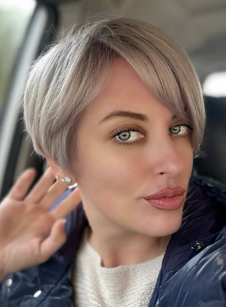 Softly Textured Ash Blonde Longer Pixie Haircut with Side-Swept Bangs