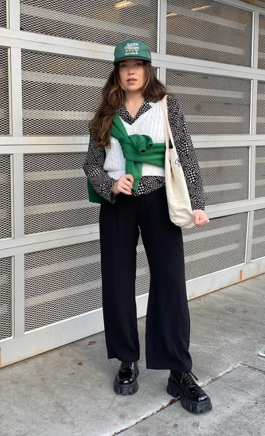 Black Polka Dot Button-Up Shirt + White Cable-Knit Sweater Vest + Black Wide-Leg Pants + Black Chunky Loafers + Green Baseball Cap