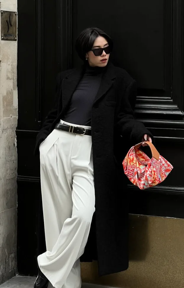 Black Turtleneck Sweater + White Wide-Leg Trousers + Black Long Coat + Black Belt + Black Ankle Boots