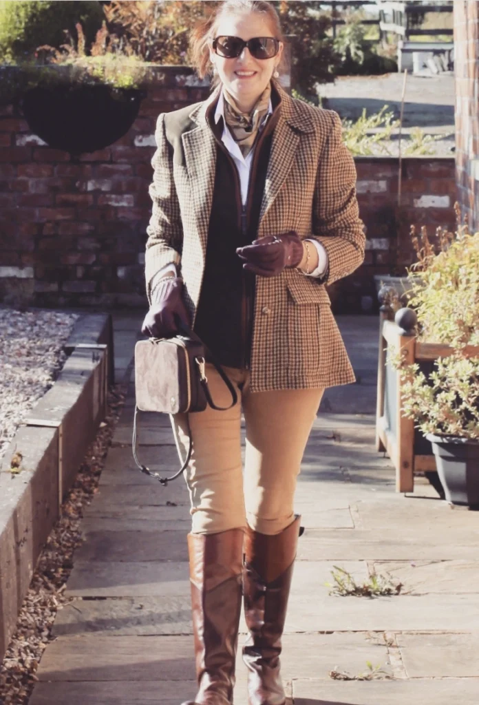 Brown Tweed Blazer + White Button-Down Shirt + Dark Knit Vest + Tan Skinny Pants + Brown Knee-High Riding Boots