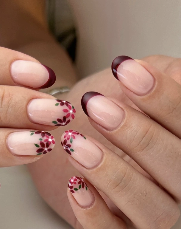 Burgundy French Tips with Floral Accents on Almond-Shaped Nails