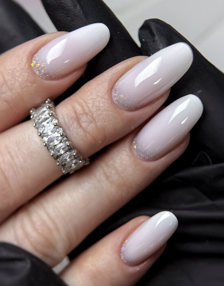 Elegant Stiletto Milky Pastel Nails with Glitter Ombre and High Gloss Finish