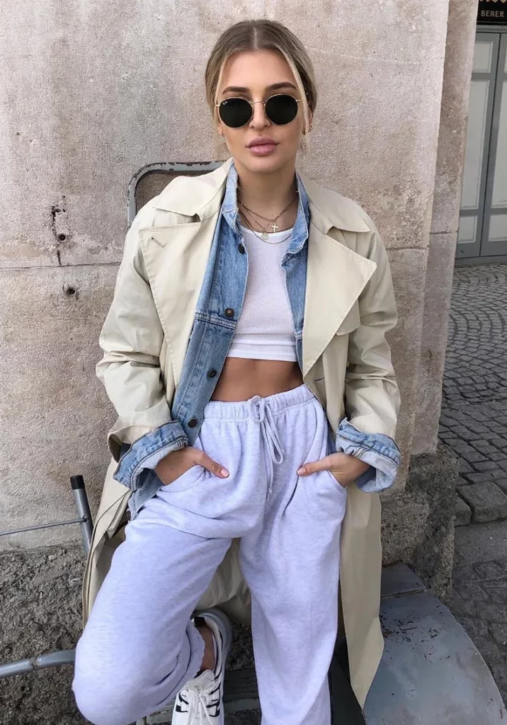 Light Beige Trench Coat + Light Blue Denim Jacket + White Cropped Tank Top + Light Gray Sweatpants + White Sneakers