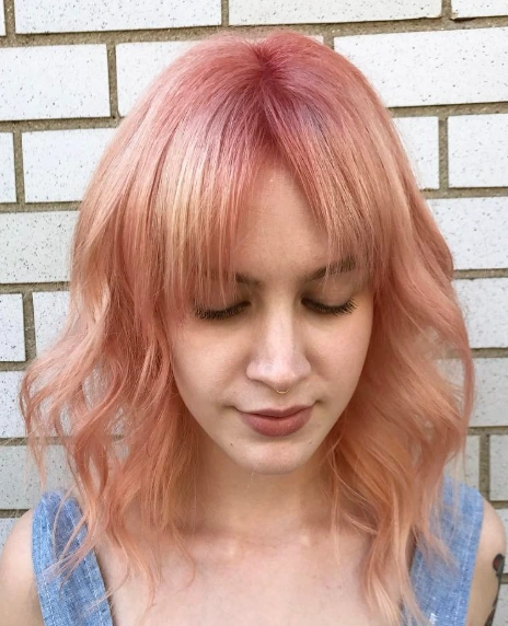 Mid-Length Wavy Bob with Blunt Bangs and Rosegold Haircolor
