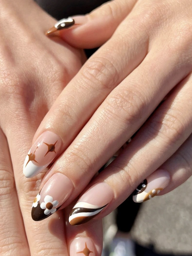 Nails in Earthy Tones with Floral Accents and Geometric Designs