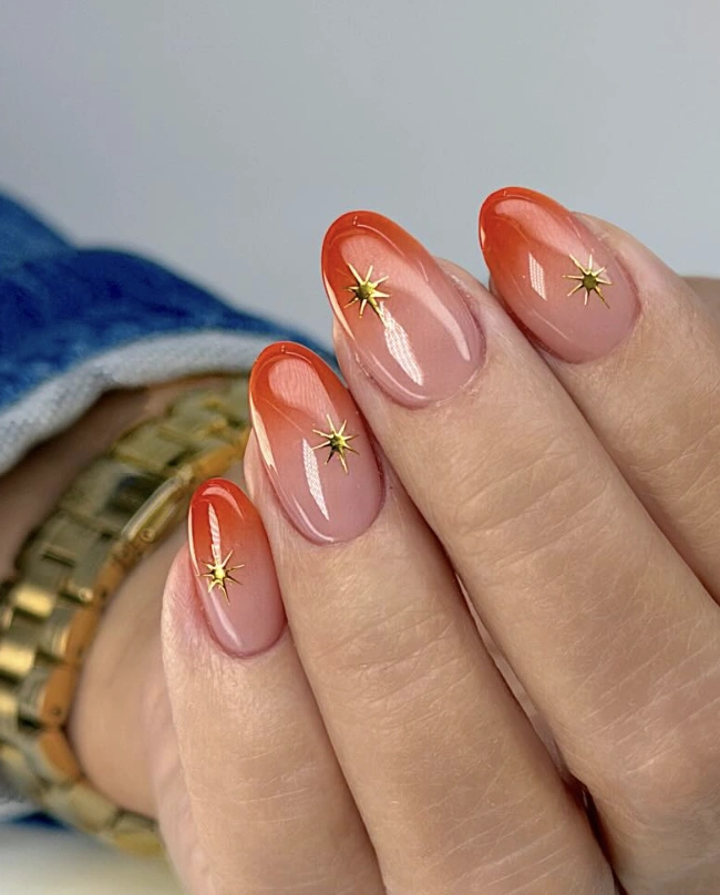Ombre Almond Nails with Neon Orange Tips and Gold Star Accents