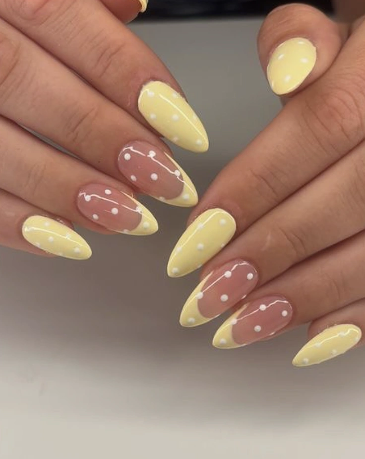 Pastel Yellow Stiletto Nails With White Polka Dots and Negative Space