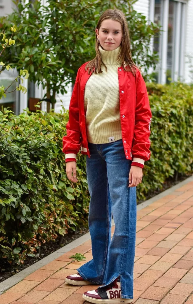 Red Bomber Jacket + Cream Turtleneck Sweater + Blue Wide-Leg Jeans + Red White Sneakers