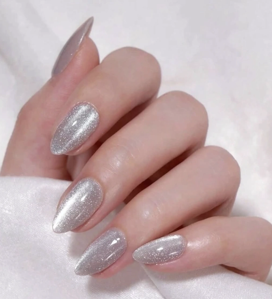 Shimmering Silver Almond Nails with Cat Eye Effect