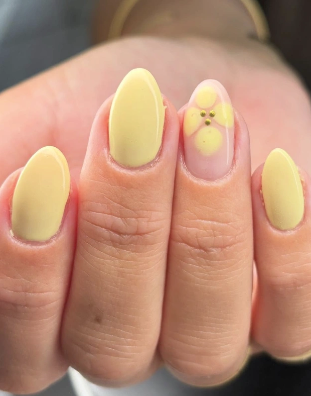 Soft Yellow Almond Nails with Subtle Floral Accent