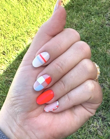 Vibrant Red and Blue Short Almond Nails with Geometric Patterns and Dazzling Accents