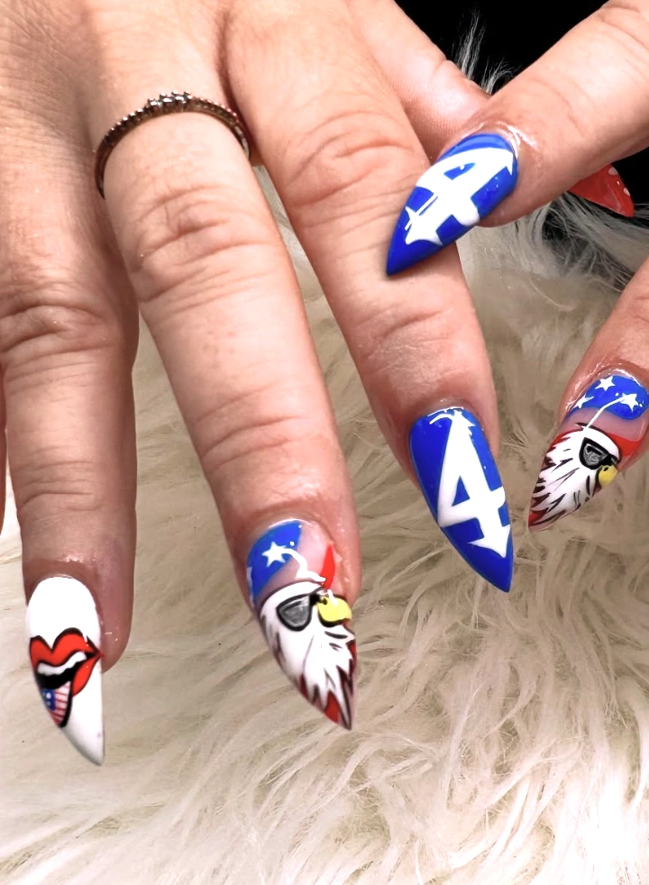 Vibrant Red, White, and Blue Stiletto July Nails with Patriotic Designs and Playful Icons