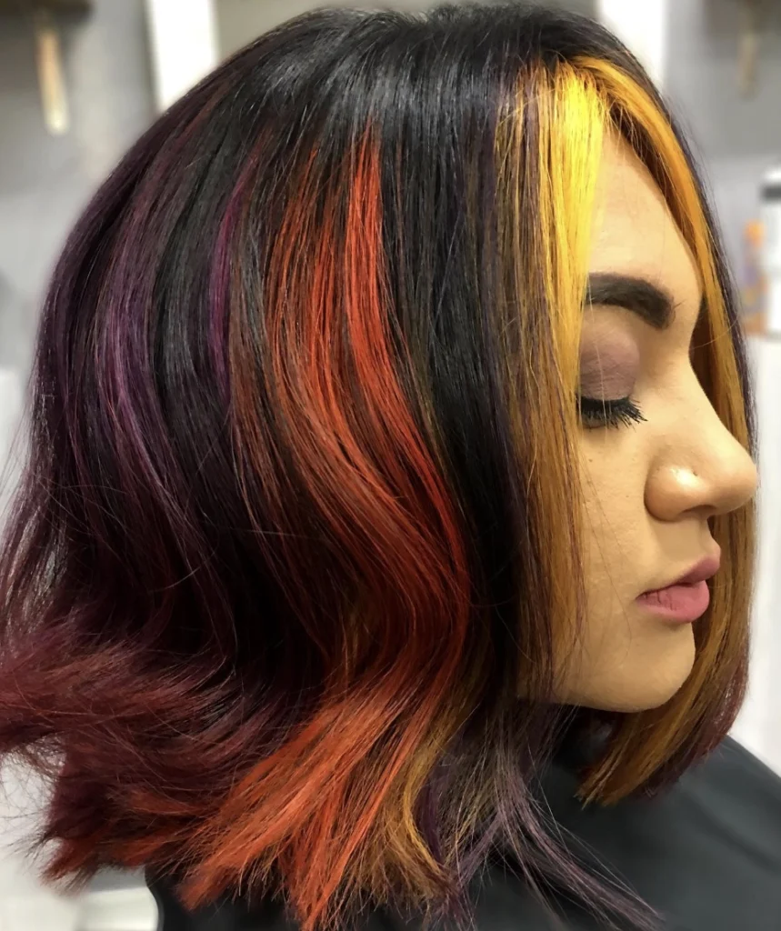 Vibrant Shoulder-Length Wavy Hair with Dark Fall Highlights and Bold Color Accents