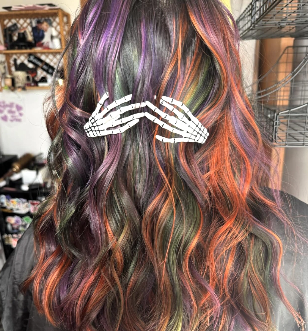 Vibrant Wavy Hairstyle with Multi-Colored Highlights and Skeleton Clip