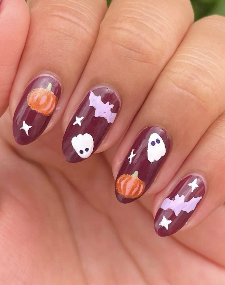 Whimsical Halloween-Inspired Coffin Nails with Ghosts, Pumpkins, and Bats on Deep Burgundy Base